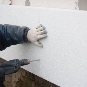 Building contractor insulating House Wall with styrofoam insulation sheets